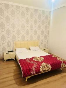 a bedroom with a large bed with a red blanket at Key Explore Hostel Hotel in Baku
