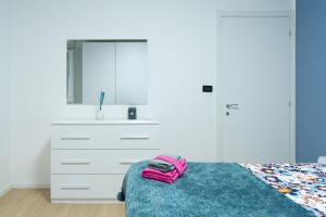 ein Schlafzimmer mit einem Bett mit einer Kommode und einem Spiegel in der Unterkunft A Casa di Emma by SMART-HOME in Genua