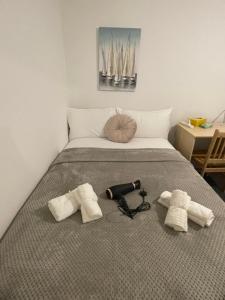 a bed with two towels and a hair dryer on it at Lovely Triple and Quadruple Bedrooms in Euston in London