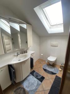 ein Badezimmer mit einem Waschbecken, einem Spiegel und einem WC in der Unterkunft Ferienwohnung Partenkirchen in Garmisch-Partenkirchen