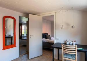 um quarto com uma mesa e um quarto com uma cama em Nyrenoveret charmerende byhus em Faaborg