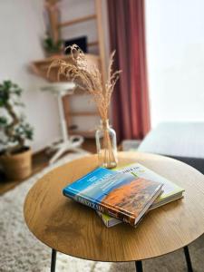una mesa con un libro y un jarrón. en Oasis Oliwa en Gdansk
