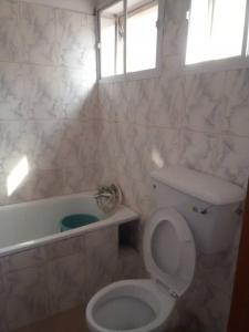 un baño con inodoro y bañera en Gifted Apartment & Residence, en Abuja 19 fotos más