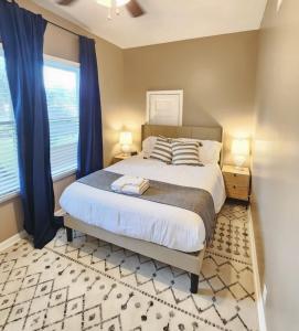 1 dormitorio con 1 cama grande y cortinas azules en Magnolia House, en Lafayette