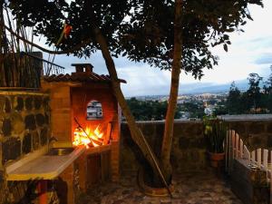 una cocina al aire libre con chimenea en una casa en Hostal Casa San Fernando Tumbaco, en Quito