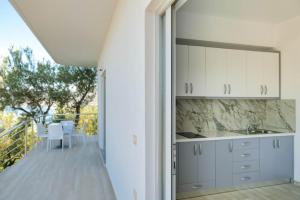 a kitchen with white cabinets and a balcony at Villa Mateo in Shkalle Stenojt