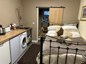 een slaapkamer met een bed en een wasmachine bij The Stable Room at The Grange in Lincolnshire