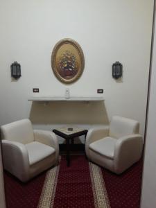 two white chairs and a table in a room at Paradise Boutique Hotel in Cairo