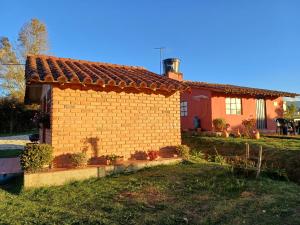 una pequeña casa de ladrillo en un patio en Mano de Oso Guasca son 3 hospedajes diversos en la ruralidad en Guasca