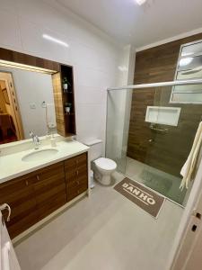 y baño con aseo, lavabo y ducha. en Apartamento Imperial no Centro de Petrópolis, en Petrópolis