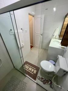 uma casa de banho com um chuveiro, um WC e um lavatório. em Apartamento Imperial no Centro de Petrópolis em Petrópolis
