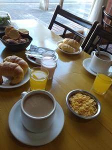 een tafel met borden vol ontbijtproducten en drankjes bij Eluney Hotel in San Clemente del Tuyú