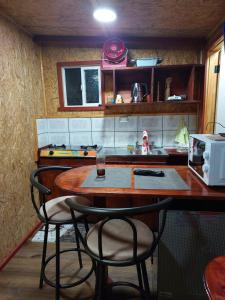 eine Küche mit einem Holztisch und zwei Stühlen in der Unterkunft Minihouse castro chiloe in Castro