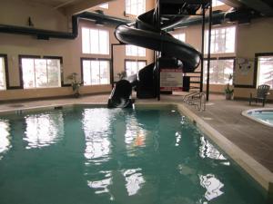 a swimming pool with a slide in a building at Super 8 by Wyndham Fort Nelson BC in Fort Nelson