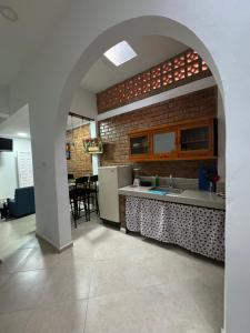a kitchen with an archway and a table and refrigerator at Apartamento angel’s in Buga