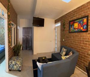 a living room with a couch and a brick wall at Apartamento angel’s in Buga