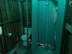 a bathroom with a toilet in a wooden stall at Miguel Surf Camp in Quepos