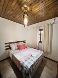 een slaapkamer met een groot bed en een houten plafond bij Ap com Sacadas, 02 quartos e churrasqueira in Palhoça