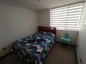 Un dormitorio con una cama y una mesa. en Vista los poetas, en Temuco