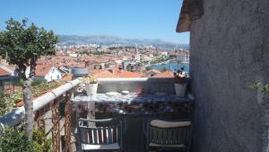 una mesa y sillas en un balcón con vistas en The Palm, en Split