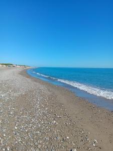 a beach with rocks and the ocean on a clear day at Stella Marina Jonica 1km vom Strand mit Terrasse in Policoro