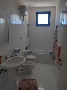 a white bathroom with a sink and a toilet at Stella Marina Jonica 1km vom Strand mit Terrasse in Policoro