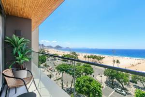 a balcony with a view of a beach and the ocean at Loft Exclusive frente Mar in Rio de Janeiro