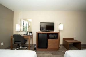 a hotel room with a television and a desk with a chair at Best Western Houston Bush IAH Intercontinental Airport Inn in Humble