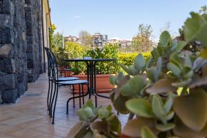 un patio con sillas, una mesa y algunas plantas en Best Western Hotel Santa Caterina, en Acireale