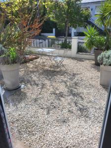 een patio met een tafel, stoelen en planten bij L'agréable in Nantes