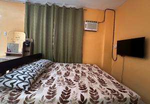 a bedroom with a bed in front of a window at Rozay Travellers Inn in Kabankalan