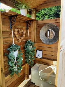 a bathroom with a toilet in a wooden wall at Wild Retreat in Cawston