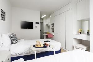 a white room with a bed and a table at Hotel Morning Sky in Seoul