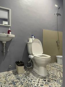a bathroom with a toilet and a sink at Cozy 2 storey fully furnished house. in Davao City