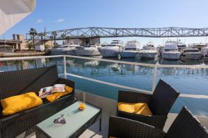 a balcony with chairs and a table and boats in the water at Unique in Barcelona ! Catamaran with a private swimming pool in Barcelona