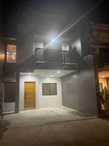 a house with a yellow door and a staircase at Cozy 2 storey fully furnished house. in Davao City