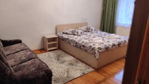 ein kleines Schlafzimmer mit einem Bett und einem Stuhl in der Unterkunft Apartament Central in Lupeni