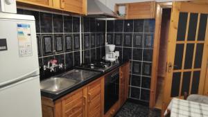 a small kitchen with a sink and a refrigerator at Apartament Central in Lupeni