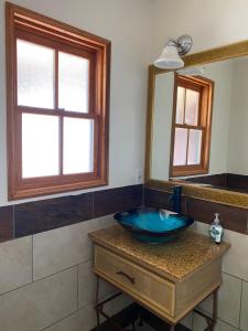 a bathroom with a blue sink and a mirror at TIDE POOL VILLAS in Santa Barbara