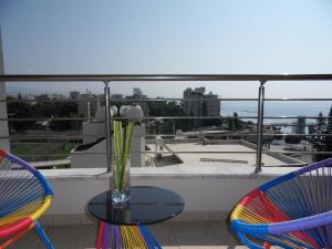 two chairs and a table with a vase on a balcony at Eden Beach Apartment 611 in Limassol