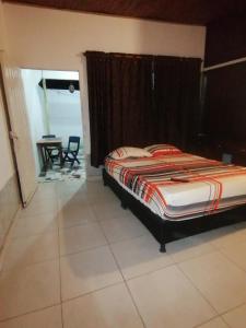 1 dormitorio con 1 cama y 1 mesa en una habitación en Casa de relajación low cost, en La Dorada