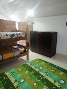 a room with two bunk beds and a flat screen tv at Casa de relajación low cost in La Dorada