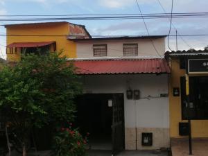 Casa blanca y amarilla con techo rojo en Casa de relajación low cost, en La Dorada