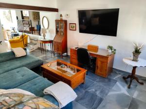 a living room with a couch and a desk and a tv at Villa Las Mercedes - Urbanización El Castillo in Fuengirola