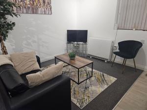 a living room with a couch and a table and a tv at Bloomsbury Apartments - Leicester in Leicester