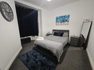 a bedroom with a bed and a clock on the wall at Bloomsbury Apartments - Leicester in Leicester