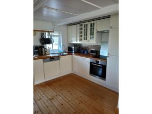 a kitchen with white cabinets and a wooden floor at Vincent family holiday home in Niederdorf