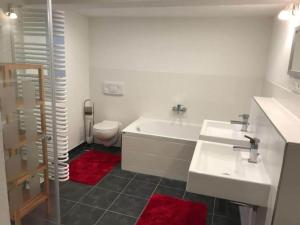 a bathroom with a tub and a toilet and a sink at Vincent family holiday home in Niederdorf