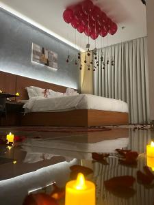 a bedroom with a bed with red umbrellas and candles at فندق كلاودز Clouds Hotel in Medina