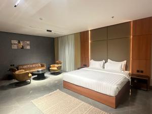 um quarto com uma cama grande e um sofá em فندق كلاودز Clouds Hotel em Al Madinah